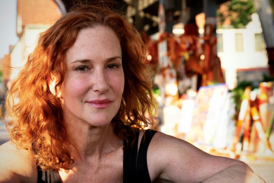 Jacqueline von Edelberg sits at a memorial for the victims of the mass shooting at a Fourth of July parade in downtown Highland Park, Illinois, on Aug. 2, 2022.