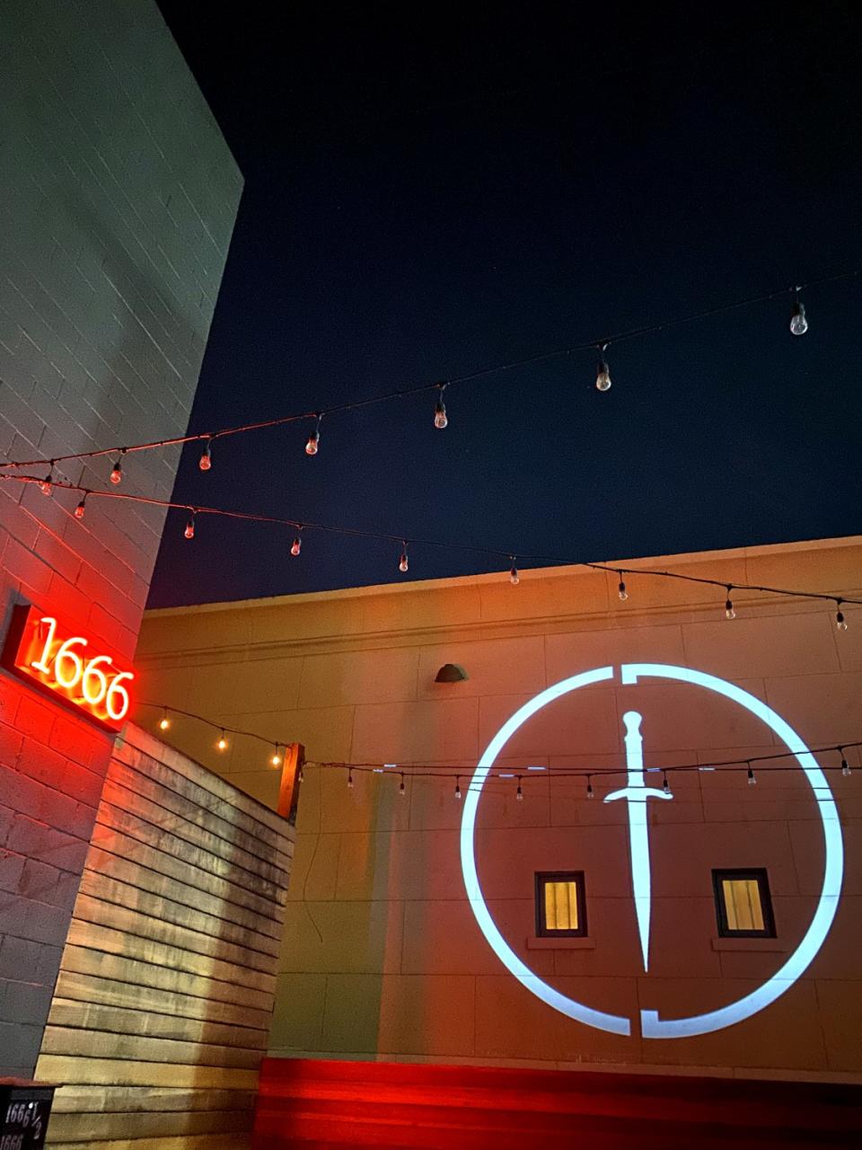 The Cloak & Dagger emblem is projected on a wall outside the club in Hollywood.