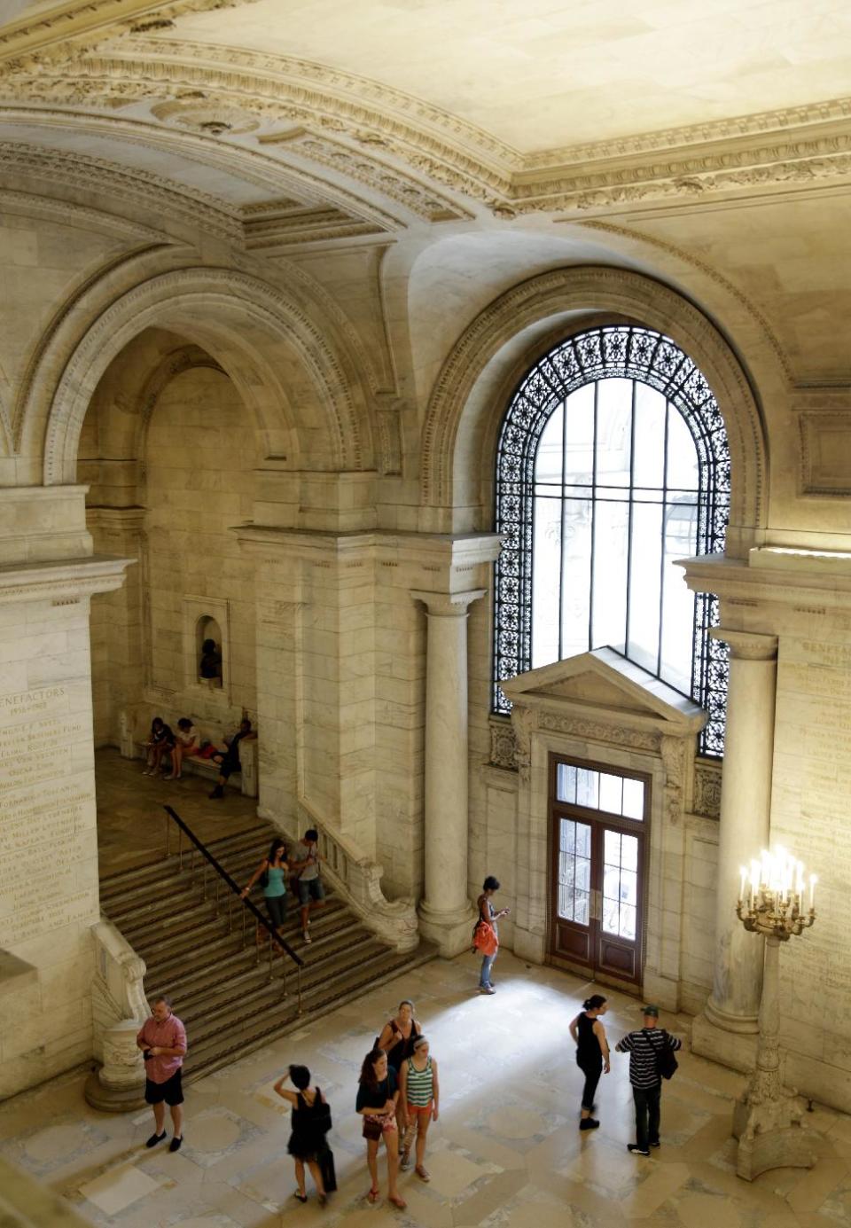 In this Monday, July 22, 2013 photo. people walk through the main branch of the New York Public Library in New York. Plans for a major change within the New York Public Library’s landmark main building have kindled an intellectual culture clash over its direction and the future of libraries themselves. (AP Photo/Seth Wenig)