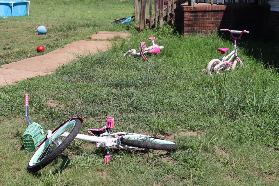 Bicycles belonging to some of Kesha Tate's nine children still line the front yard of her home on Thursday, Sept. 1, 2022 in Gaffney, S.C. The South Carolina family is seeking justice for Tate killed by her neighbor who was intoxicated and making target practice in his backyard. Nicholas Skylar Lucas is accused of murder in the shooting death of Tate after crime scene technicians debunked his claim that the shots ricocheted off his target. (AP Photo/James Pollard)