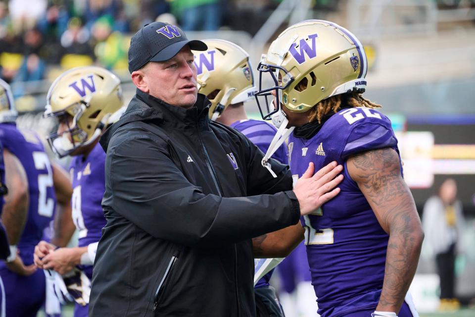 Washington coach Kalen DeBoer visits with running back Cameron Davis (22) during warm ups before a game in 2022 against Oregon at Autzen Stadium.