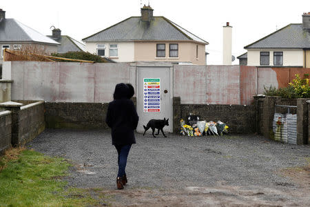 A woman walks her dog near to the site where the remains of an unknown number of babies and toddlers were found buried, in what used to be the grounds of the mother-and-baby home run by the Bon Secours nuns, in Tuam, western Ireland March 7, 2017. REUTERS/Peter Nicholls