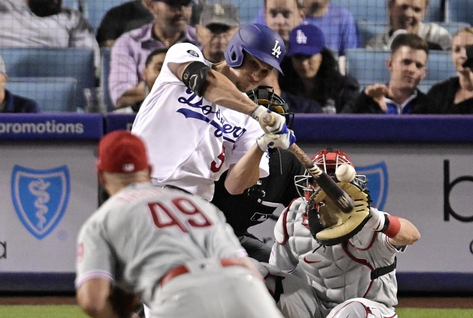 Los Angeles Dodgers' Corey Seager, right, hits a two-run home run as Philadelphia Phillies starting pitcher Jake Arrieta, left, and catcher J.T. Realmuto watch during the fifth inning of a baseball game Friday, May 31, 2019, in Los Angeles. (AP Photo/Mark J. Terrill)