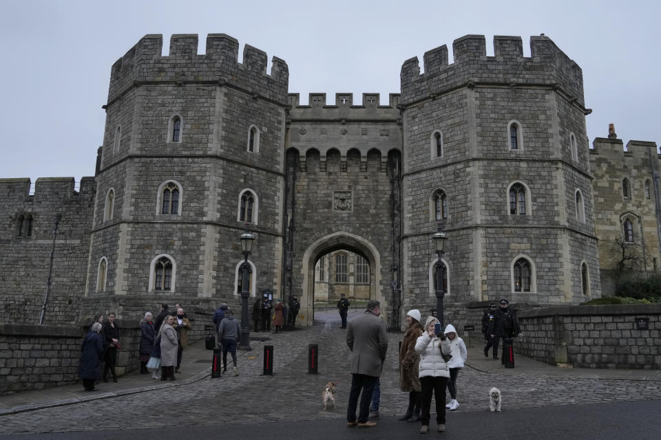 Tourist stand in front of the Henry VII gate and take pictures at Windsor castle at Windsor, England on Christmas Day, Saturday, Dec. 25, 2021. Britain's Queen Elizabeth II has stayed at Windsor Castle instead of spending Christmas at her Sandringham estate due to the ongoing COVID-19 pandemic. (AP Photo/Alastair Grant)