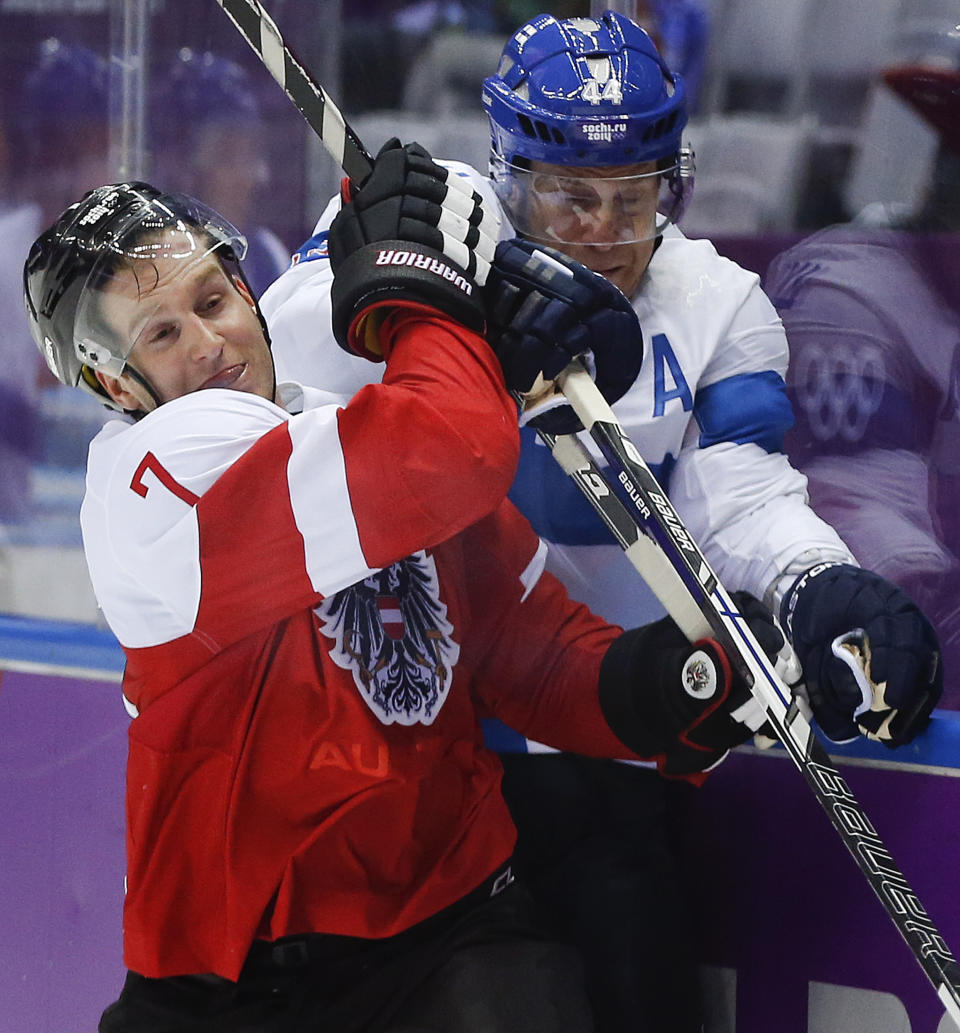 Austria defenseman Stefan Ulmer (7) collides with Finland defenseman Kimmo Timonen in the second period of a men's ice hockey game at the 2014 Winter Olympics, Thursday, Feb. 13, 2014, in Sochi, Russia. (AP Photo/Julio Cortez)