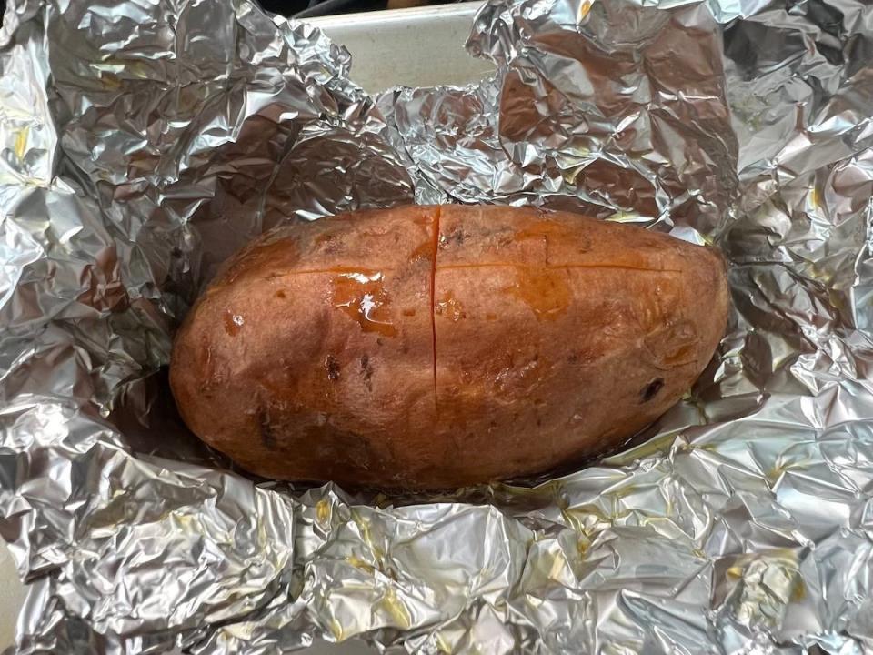 A baked sweet potato on a sheet of foil.