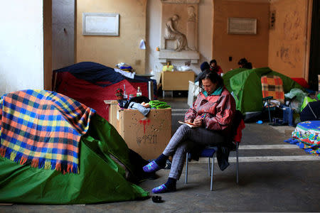 Angela Grossi sits next to her tent in the portico of the Basilica of the Santi Apostoli, where she lives after being evicted from an unused building along with other families in August 2017, in Rome, Italy January 29, 2018. Picture taken January 29, 2018. REUTERS/Tony Gentile