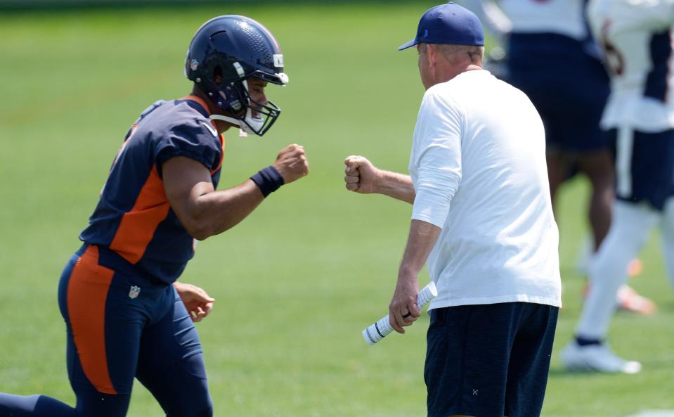 Denver Broncos quarterback Russell Wilson, left, bumps fists with head coach Sean Payton during NFL football practice, Wednesday, June 14, 2023, in Centennial, Colo.
