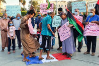 Demonstrators stamp with their feet on a French national flag during a rally protesting against the comments of French President Emmanuel Macron over Prophet Mohammed cartoons, at the Martyrs' Square of Libya's capital Tripoli on October 25, 2020. (Photo by Mahmud TURKIA / AFP) (Photo by MAHMUD TURKIA/AFP via Getty Images)