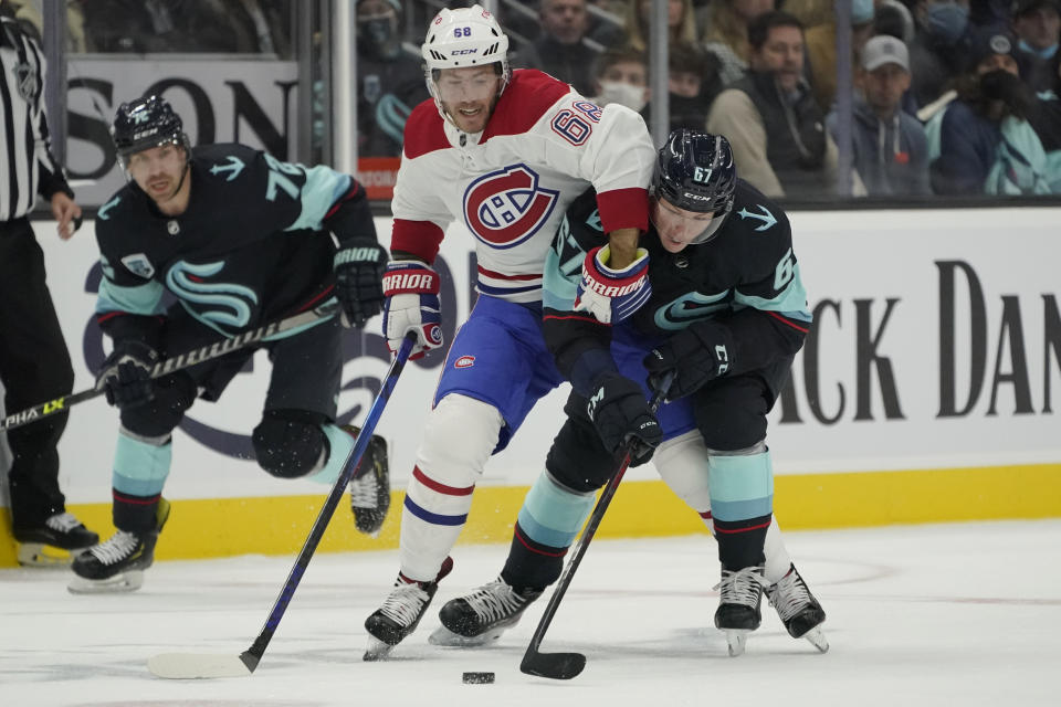 Montreal Canadiens center Mike Hoffman (68) battles with Seattle Kraken center Morgan Geekie (67) for the puck during the third period of an NHL hockey game, Tuesday, Oct. 26, 2021, in Seattle. The Kraken won 5-1. (AP Photo/Ted S. Warren)