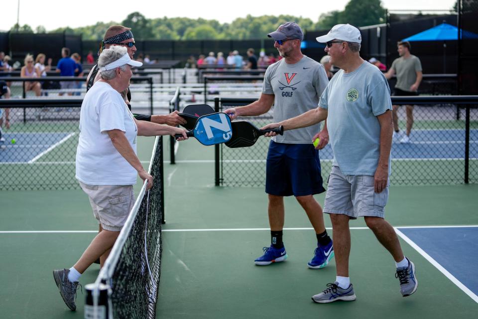 11 de julio de 2023; Nueva Albany, Ohio, EE. UU.; Desde la izquierda, Debbie Rutan, Jim Olive, Travis Snead y Phil Rutan golpean las paletas al final de su partido de pickleball durante la gran inauguración del New Albany Pickleball Complex en Bevelhymer Park.