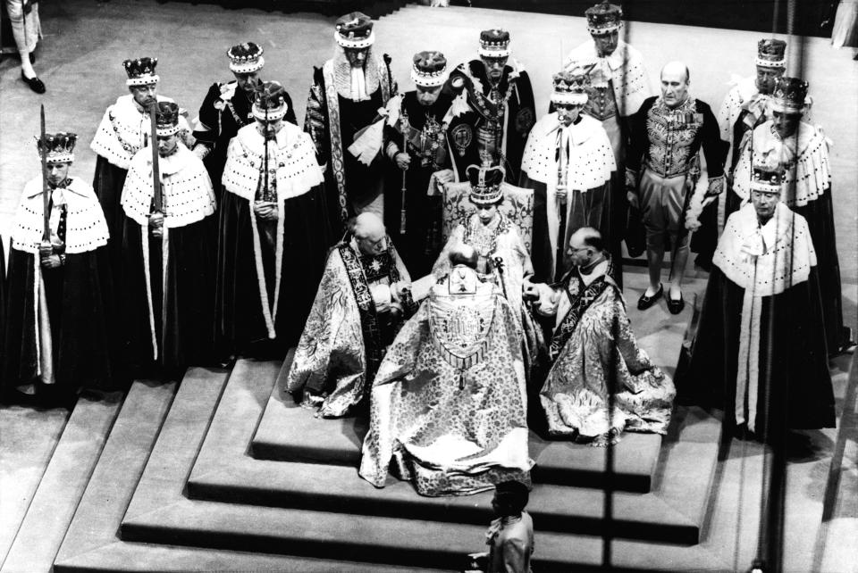 FILE - Britain's Queen Elizabeth II, seated on the throne, receives the fealty of the Archbishop of Canterbury, center with back to camera; the Bishop of Durham, left; and the Bishop of Bath and Wells; during her coronation ceremony, June 2, 1953, in London's Westminster Abbey. (AP Photo, File)