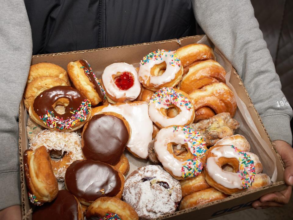 Street vendor carrying box of doughnuts