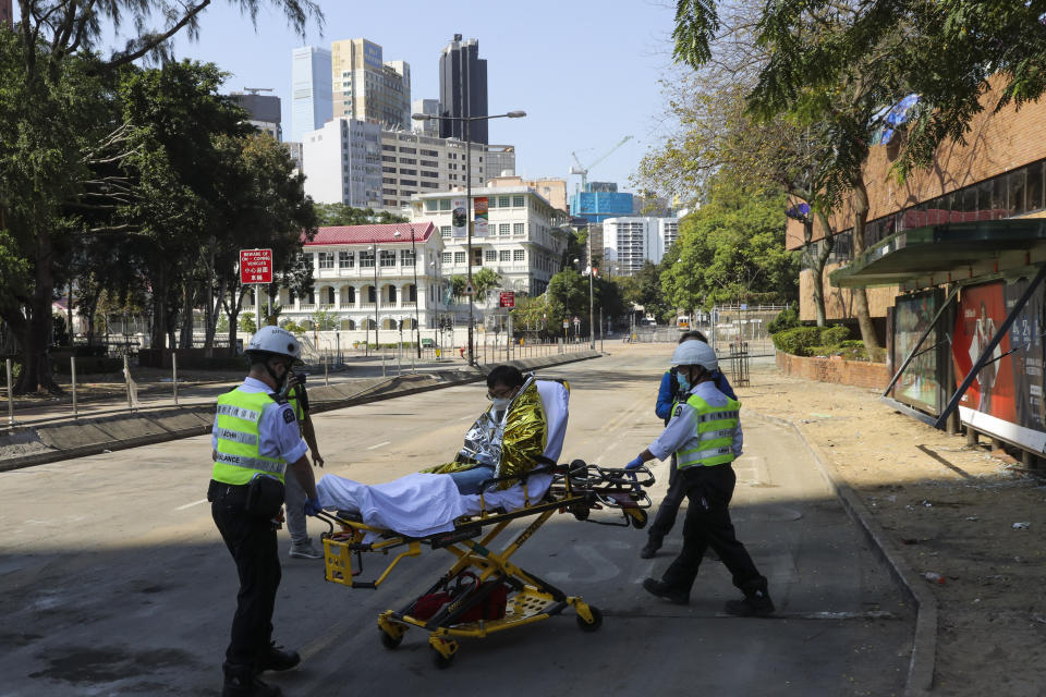 A protester is wheeled on a stretcher by first aid personnel as they leave the Polytechnic University campus in Hong Kong, Thursday, Nov. 21, 2019. A small group of protesters refused to leave Hong Kong Polytechnic University, the remnants of hundreds who took over the campus for several days. (AP Photo/Vincent Thian)