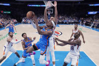 Oklahoma City Thunder guard Shai Gilgeous-Alexander (2) goes to the basket in front of Phoenix Suns guard Landry Shamet, rear, and center Bismack Biyombo (18) in the second half of an NBA basketball game Sunday, April 2, 2023, in Oklahoma City. (AP Photo/Sue Ogrocki)