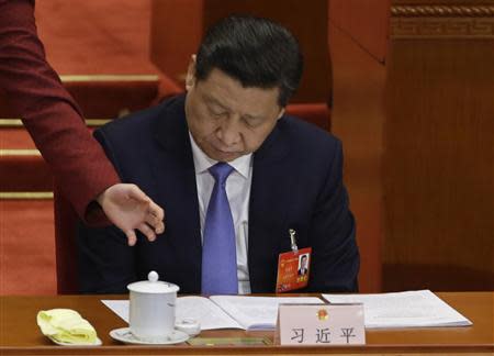 An attendant serves tea for China's President Xi Jinping during the opening session of the National People's Congress (NPC) at the Great Hall of the People in Beijing, March 5, 2014. REUTERS/Jason Lee