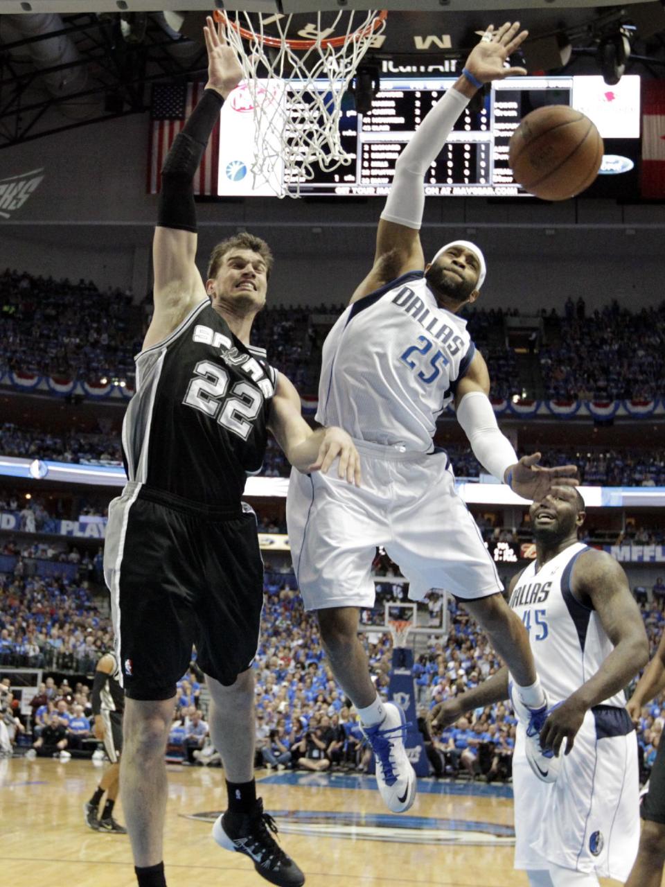 San Antonio Spurs' Tiago Splitter (22), of Brazil, has a shot disrupted by Dallas Mavericks' Vince Carter (25) as Mavericks' DeJuan Blair (45) watches in the first half of Game 6 of an NBA basketball first-round playoff series on Friday, May 2, 2014, in Dallas. (AP Photo/Tony Gutierrez)