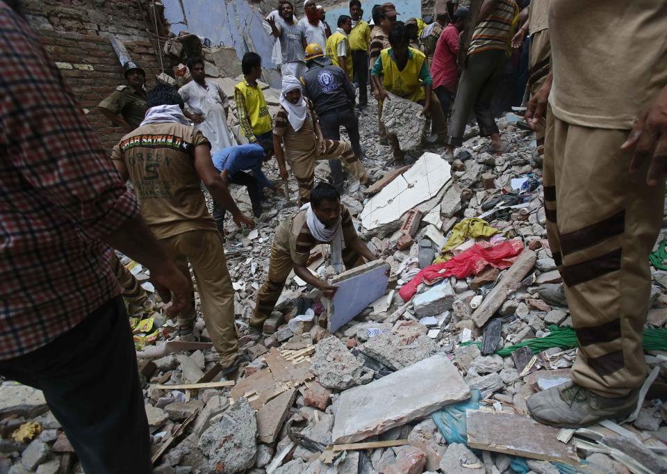 Rescue workers clear the debris from the site of a collapsed building in New Delhi