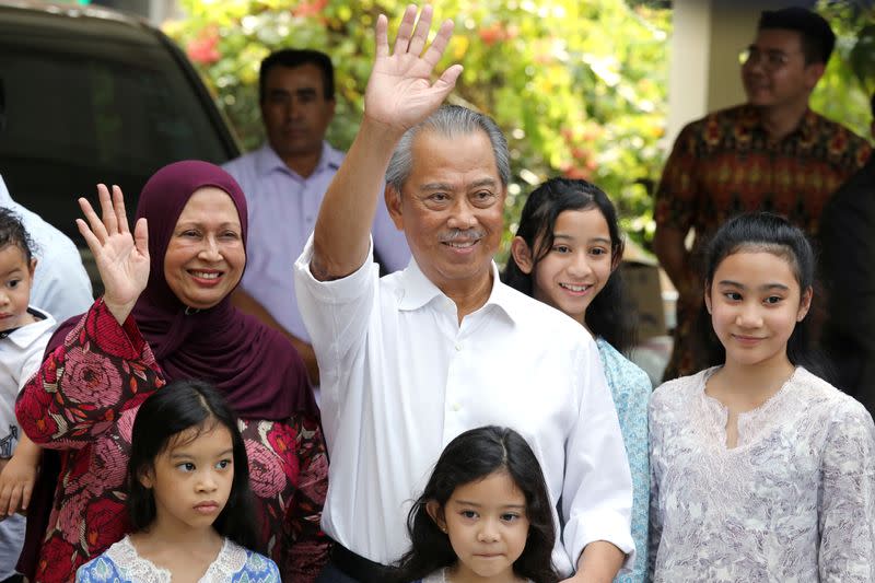 Malaysia's Prime Minister Designate and former interior minister Muhyiddin Yassin waves to reporters outside his residence in Kuala Lumpur