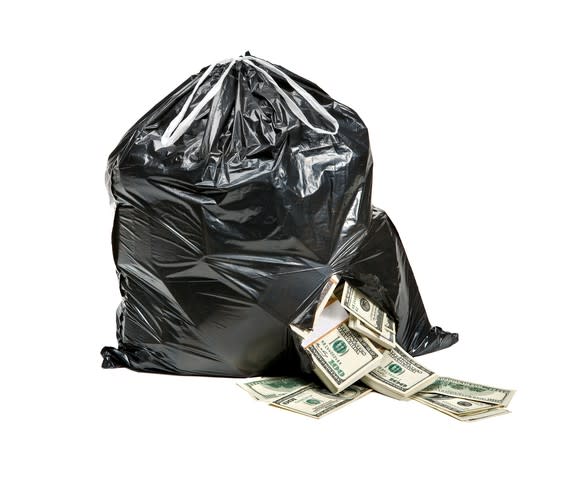 Cash spilling out of a ripped garbage bag