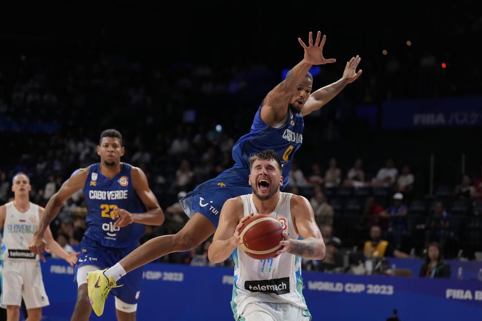 Slovenia guard Luka Doncic (77), center, tries to shoot against Cape Verde guard Patrick Lima (0) in the second half of their Basketball World Cup group F match in Okinawa, southern Japan, Wednesday, Aug. 30, 2023. (AP Photo/Hiro Komae)