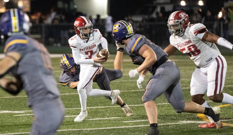 Patterson quarterback Max Medina rolls out under pressure from Escalon defenders during the Sac-Joaquin Section Division IV championship game at St. Mary’s High School in Stockton, Calif., Friday, Nov. 24, 2023.