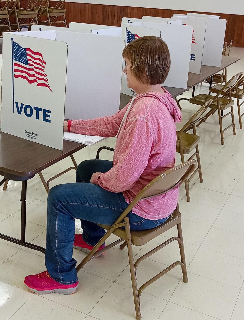 Susan Schie looks over her ballot at the Holmes County Catholic Center in Millersburg. Precinct workers there reported extremely light voter turnout on a cold and wet May 2.