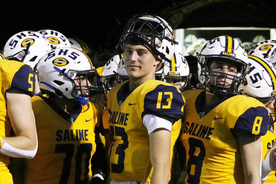 Saline High School quarterback CJ Carr (13) looks on before a football game Friday, Oct. 27, 2023, in Saline, Mich. Carr will be among the hundreds of football players to sign a national letter of intent this week, sealing his commitment to join Notre Dame, but no one has a story quite the same. (AP Photo/Carlos Osorio)