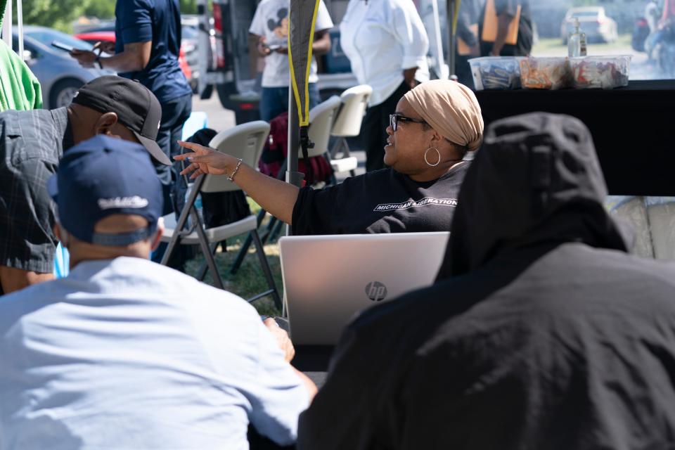 Communications director for Michigan Liberation Marjon Parham, middle, helps sign in metro Detroiters hoping for help expunging their criminal records Aug. 12, 2022 at the Center for the Works of Mercy in Detroit.