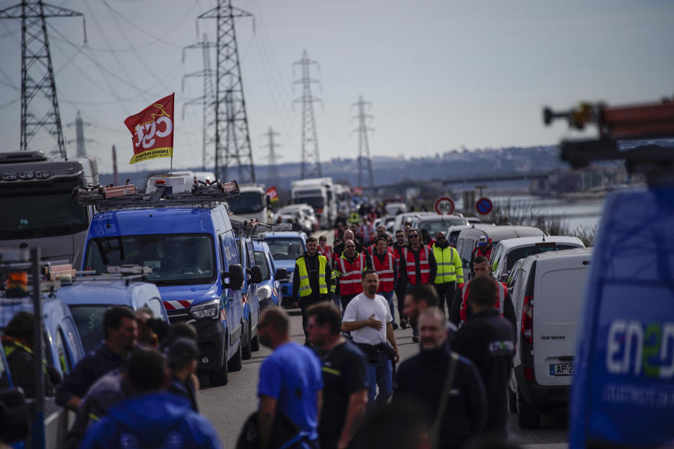 Oil workers on strike block the access to an oil depot in Foss-sur-Mer, southern France, Tuesday, March 21, 2023. The bill pushed through by President Emmanuel Macron without lawmakers' approval still faces a review by the Constitutional Council before it can be signed into law. Meanwhile, oil shipments in the country were disrupted amid strikes at several refineries in western and southern France. (AP Photo/Daniel Cole)