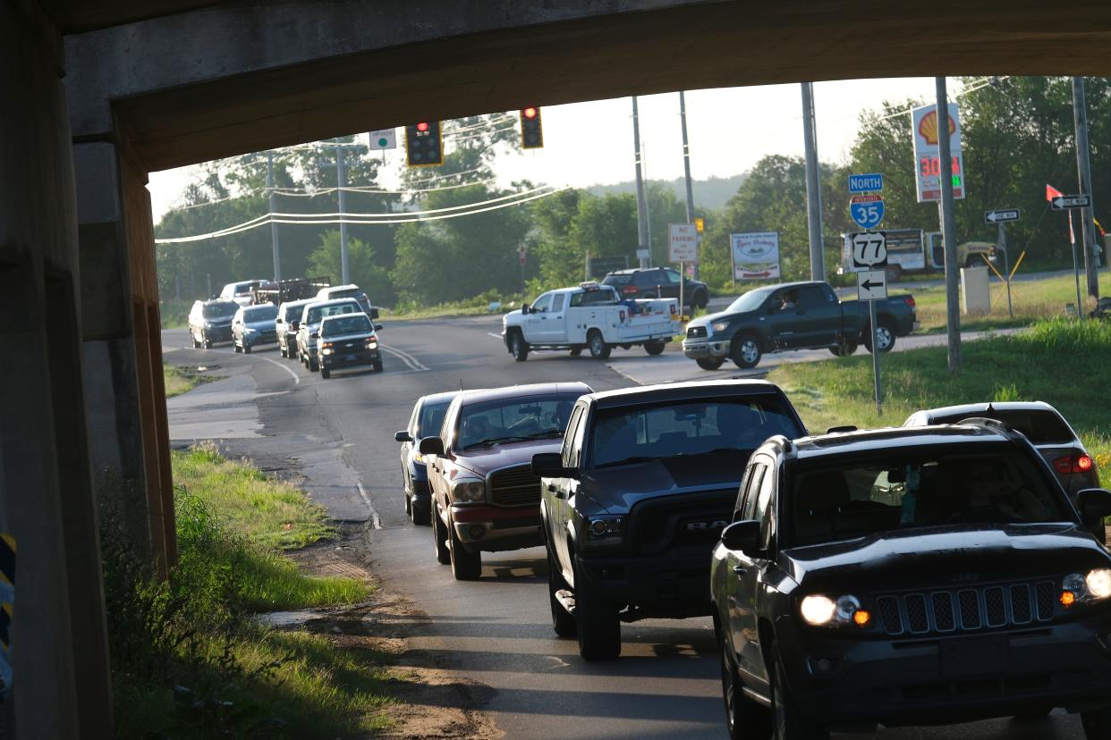 Looking back east from under I-35 at Waterloo. Morning rush hour traffic along Waterloo Road near Sooner Road. Wednesday, July 12, 2023