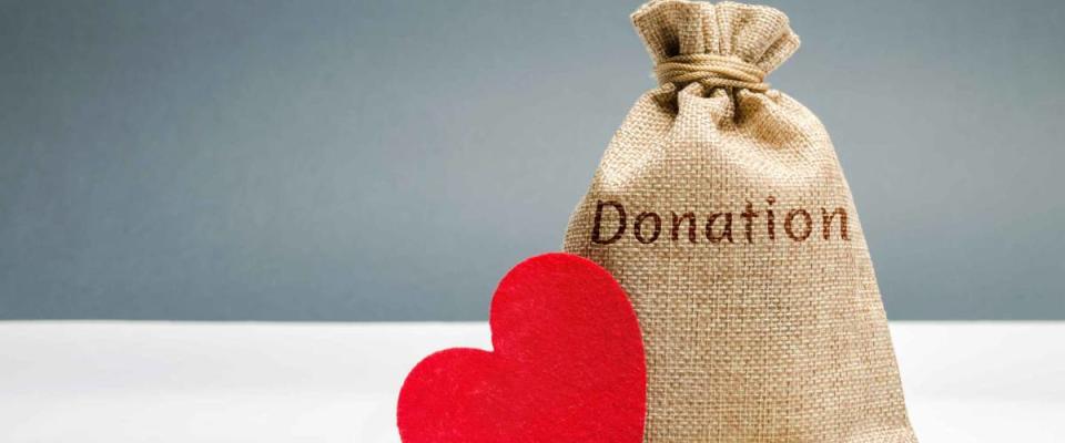 A money bag with the word Donation and a red heart. Accumulation of money for a medical donation. Health care. Saving. Social medical help from volunteers. Charitable foundation