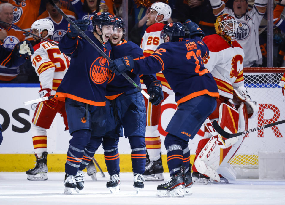 Calgary Flames look away as Edmonton Oilers center Ryan Nugent-Hopkins, front left, celebrates his goal against the Calgary Flames during the third period of Game 4 of an NHL hockey Stanley Cup playoffs second-round series Tuesday, May 24, 2022, in Edmonton, Alberta. (Jeff McIntosh/The Canadian Press via AP)