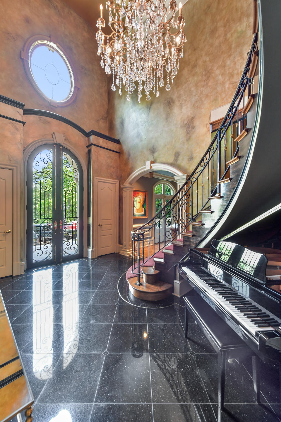 The entryway of the nearly 7,000-square-foot home opens into a sweeping staircase. (Photo credit: Josh Vick, HomeTour America)