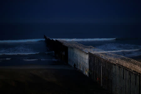 A man jogs next to the border wall between Mexico and the U.S., in Tijuana, Mexico, December 10, 2018. REUTERS/Carlos Garcia Rawlins