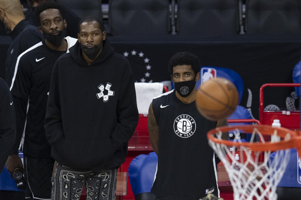 Kevin Durant and Kyrie Irving watch from the sidelines as their Brooklyn Nets lose to the Philadelphia 76ers in a game that tilted the standings. (Mitchell Leff/Getty Images)