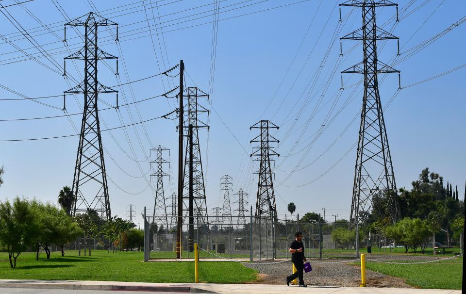 A pedestrian walks past a row of power lines in Rosemead, California, on October 9, as southern California braces for potentially widespread power outages. (Photo by Frederic J. BROWN / AFP) (Photo by FREDERIC J. BROWN/AFP via Getty Images) (Photo: FREDERIC J. BROWN via Getty Images)