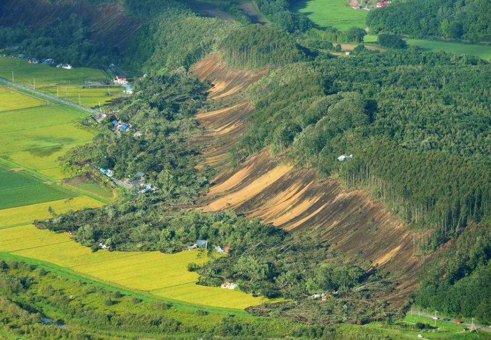 <p>This picture shows an aerial view of houses damaged by a landslide in Atsuma town, Hokkaido prefecture on Sept. 6, 2018, after an earthquake hit the northern Japanese island of Hokkaido. A powerful 6.6 magnitude quake hit the northern Japanese island of Hokkaido on Sept. 6, triggering landslides, bringing down several houses, and killing at least one person with several dozen missing. (Photo from Jiji Press/AFP/Getty Images) </p>