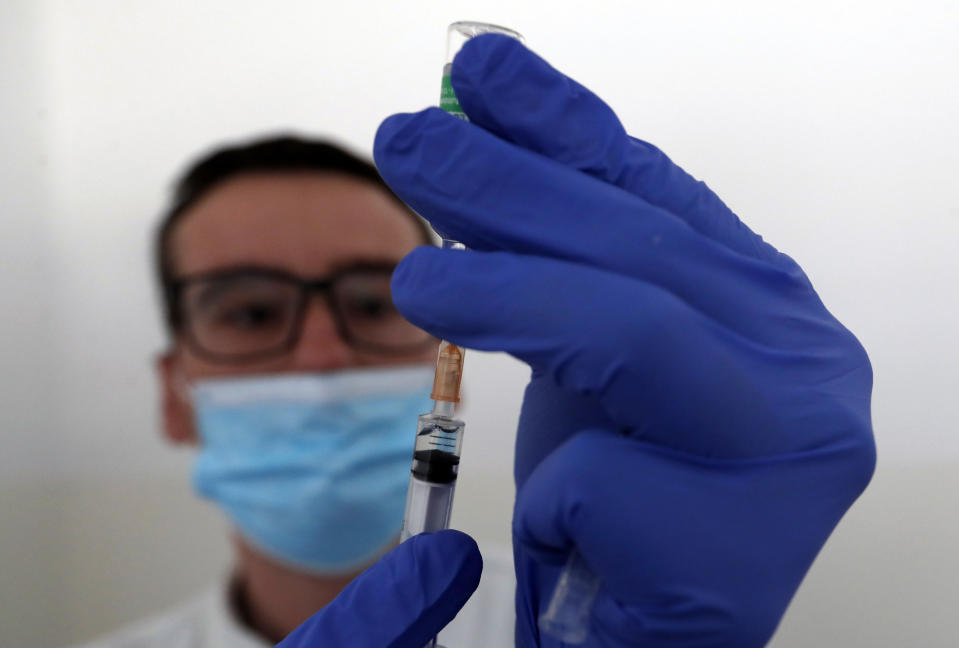 A medical worker prepares to administer a dose of the AstraZeneca vaccine during the vaccination in the "Krnjaca" refugee centre near Belgrade, Serbia, Friday, March 26, 2021. Serbia has started vaccinating migrants as the Balkan country struggles with a new coronavirus outbreak despite a widespread inoculation campaign. (AP Photo/Darko Vojinovic)