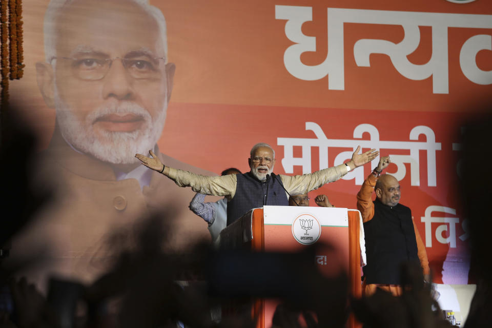 Indian Prime Minister Narendra Modi addresses party supporters, standing next to his Bharatiya Janata Party (BJP) President Amit Shah at their headquarters in New Delhi, India, Thursday, May 23, 2019. Modi's Hindu nationalist party claimed it won reelection with a commanding lead in Thursday's vote count, while the head of the main opposition party conceded a personal defeat that signaled the end of an era for modern India's main political dynasty. (AP Photo/Manish Swarup)