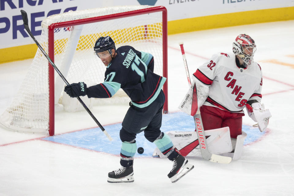 Seattle Kraken center Jaden Schwartz (17) celebrates after a goal by defenseman Vince Dunn as Carolina Hurricanes goaltender Antti Raanta (32) looks on during the second period of an NHL hockey game Thursday, Oct. 19, 2023, in Seattle. (AP Photo/Jason Redmond)