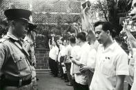 In this South China Morning Post (SCMP) archive photo taken on May 16, 1967, protesters wave their Little Red Books, 'The Quotations from Chairman Mao Zedong', in front of police outside the South Kowloon Magistracy in Hong Kong