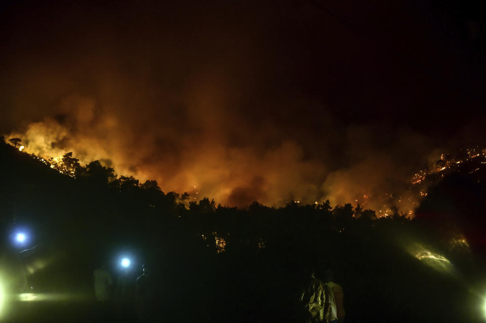 Advancing fires rage the Hisaronu area, Turkey, late Monday, Aug. 2, 2021. For the sixth straight day, Turkish firefighters battled Monday to control the blazes that are tearing through forests near Turkey's beach destinations. Fed by strong winds and scorching temperatures, the fires that began Wednesday have left eight people dead. Residents and tourists have fled vacation resorts in flotillas of small boats or convoys of cars and trucks. (AP Photo)