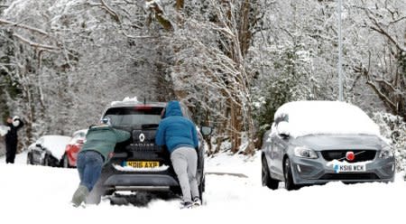 Members of the public push a car up a hill in Leverstock Green, Hertfordshire, Britain, December 10, 2017. REUTERS/Paul Childs