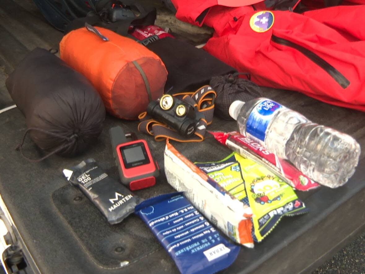 North Shore Rescue team leader Mike Danks laid out the essential gear he says rescue workers carry with them at all times when they're out in the B.C. backcountry. (Yasmin Gandham/CBC - image credit)