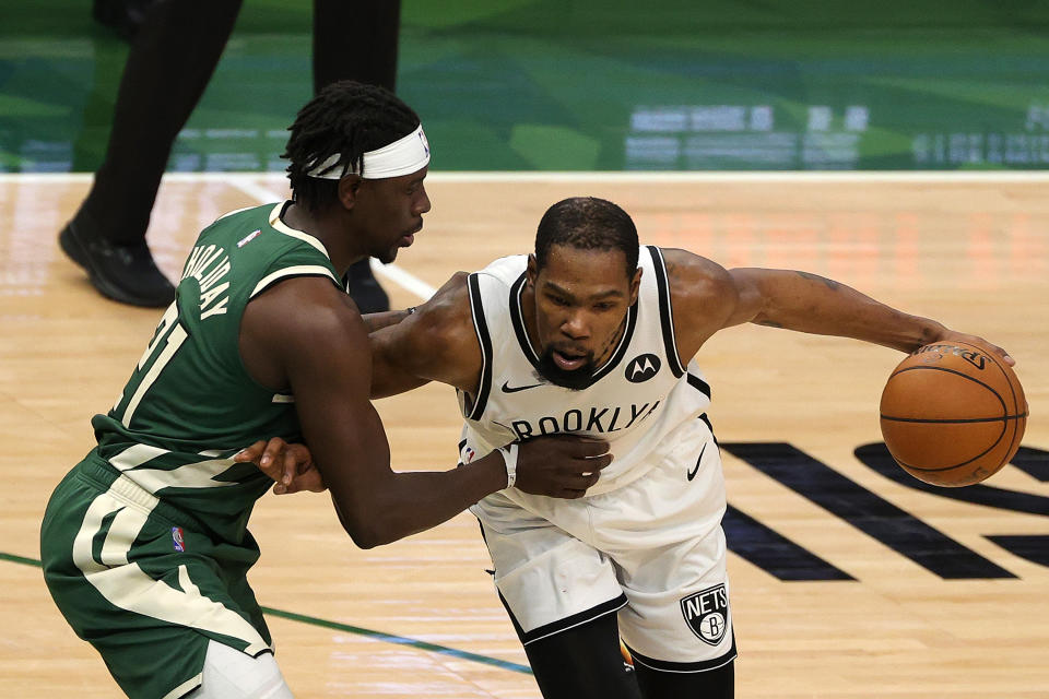 Kevin Durant tries to drive around Jrue Holiday.