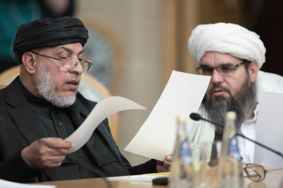 Participants of the conference on Afghanistan including representatives of the Afghan authorities and the Taliban read papers in Moscow, Russia, Friday, Nov. 9, 2018. The conference marks Moscow's attempt to get the Afghan authorities and the Taliban together at a table. The U.S. Embassy in Moscow has sent a diplomat to observe the discussions. (AP Photo/Pavel Golovkin)