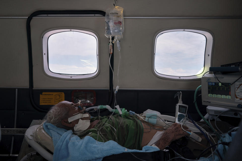 COVID-19 patient Sildomar Castelo Branco, 89, is treated onboard an aircraft as he is transferred from Santo Antônio do Iça to a hospital in Manaus in Brazil's Amazon state, Tuesday, May 19, 2020. (AP Photo/Felipe Dana)