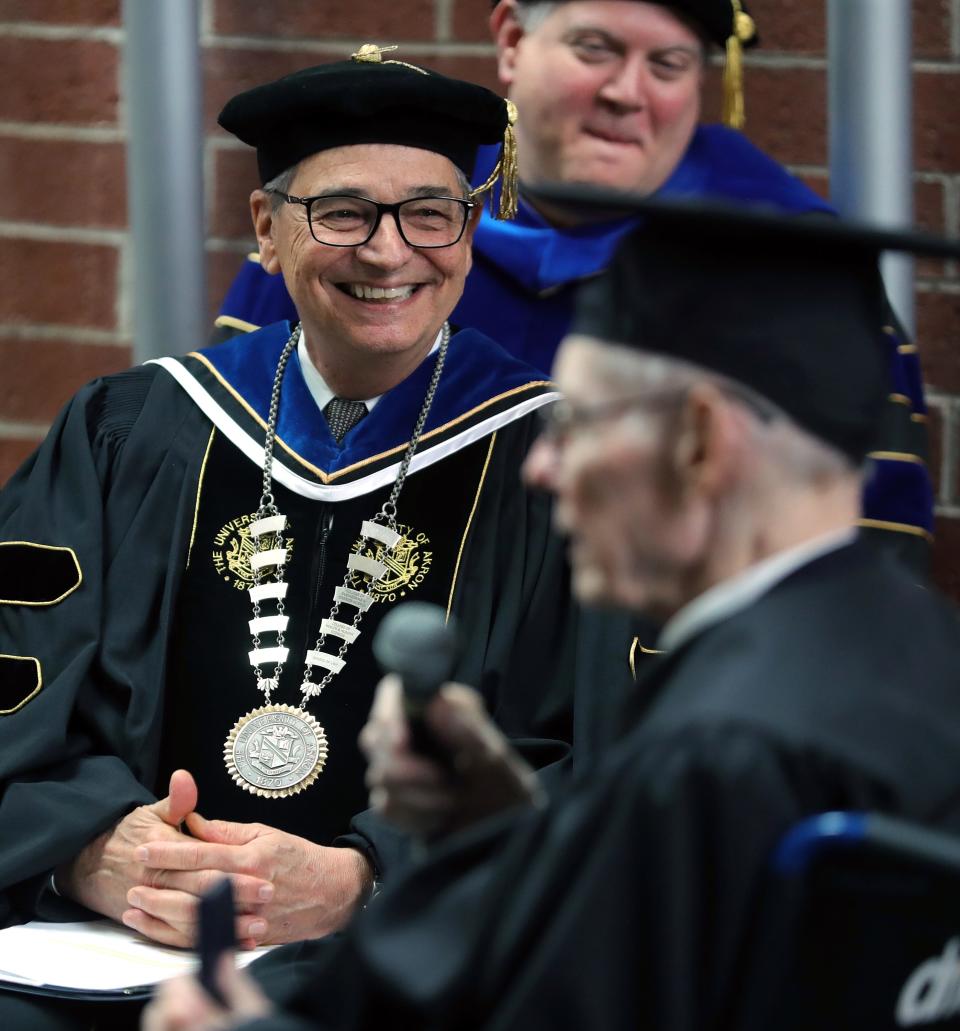 University of Akron President Gary Miller chuckles as he listens to Robert Greathouse's speech during his graduation ceremony Monday.