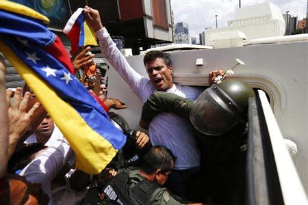 Venezuelan opposition leader Leopoldo Lopez gets into a National Guard armored vehicle in Caracas February 18, 2014. REUTERS/Jorge Silva